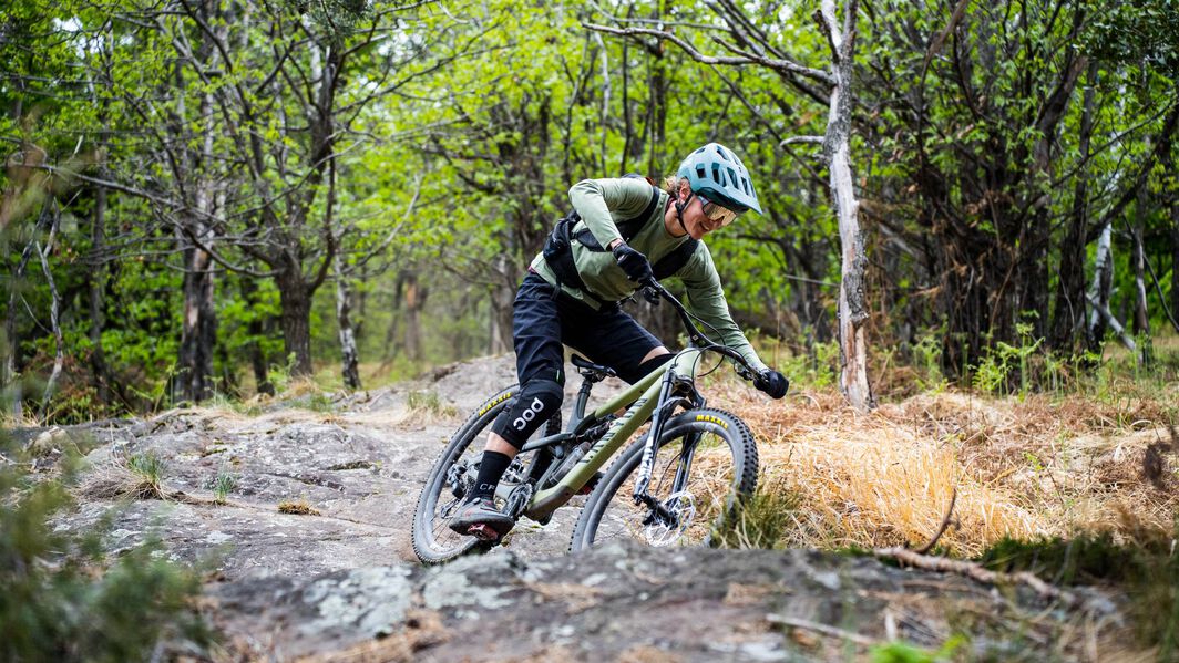 Ines Thoma rides a Canyon Spectral mountain bike down a rocky mountain bike trail in Italy.